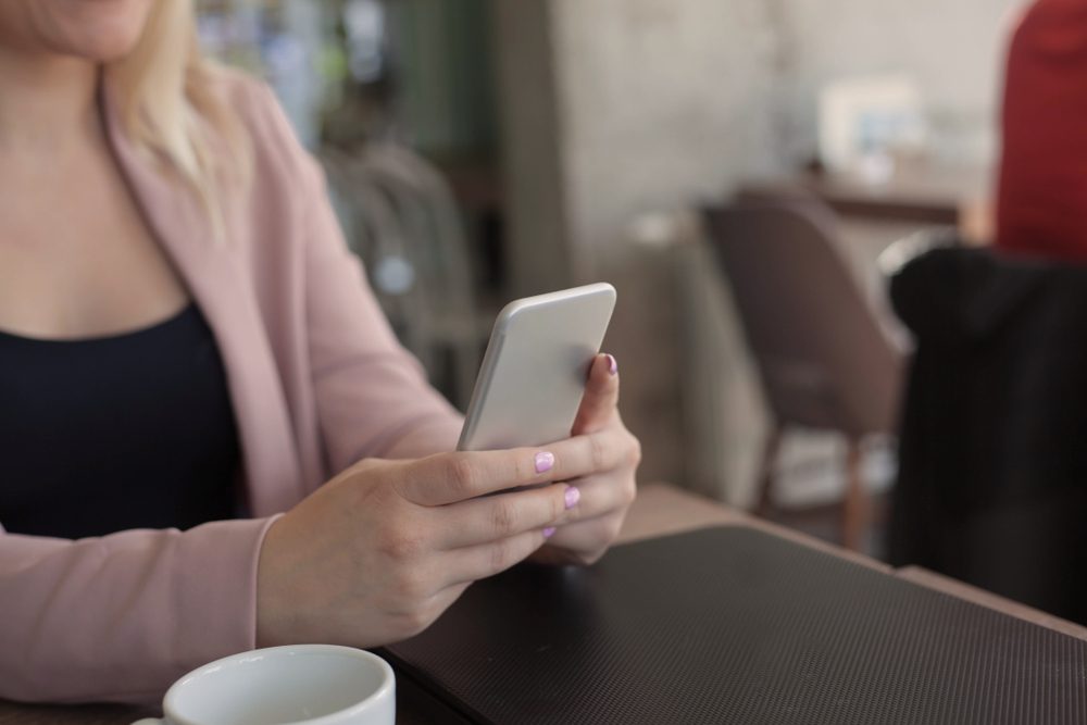 Close up photo of woman hand using phone.