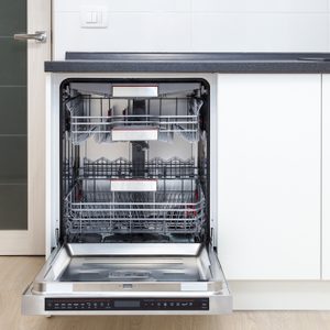 Build-in dishwasher with opened door in a white kitchen 