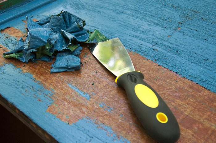 renovation furniture - removing blue painting with spatula