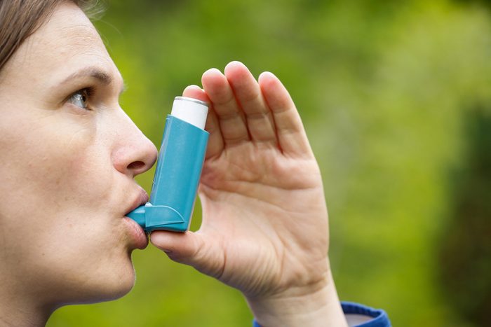 Asthma patient inhaling medication for treating shortness of breath and wheezing. Chronic disease control, allergy induced asthma remedy and chronic pulmonary disease concept.