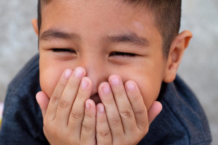Boy covering mouth