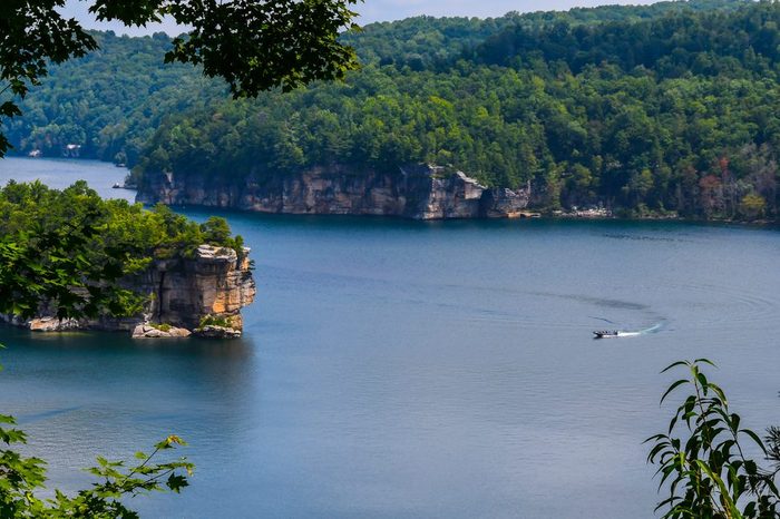 Curves in Summersville Lake in the mountains of West Virginia as a boat passes making a curved wake in the curve of the lake