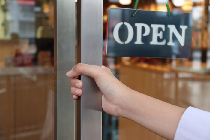hand on handle door for open to entering restaurant