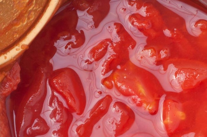 a top view of opened can of diced tomatoes on white table