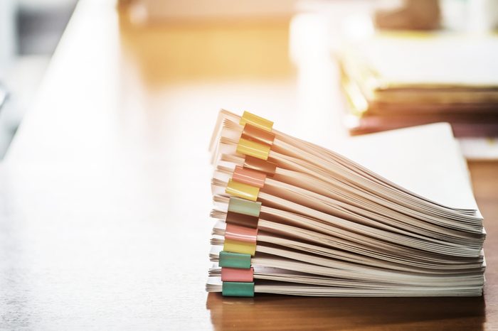 Paper documents stacked on wooden desk at workplace.Business Concept.