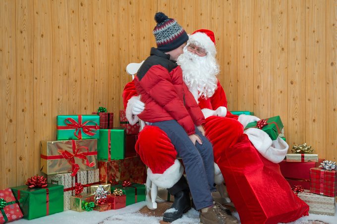 A boy visiting Santa in his grotto at Christmas.