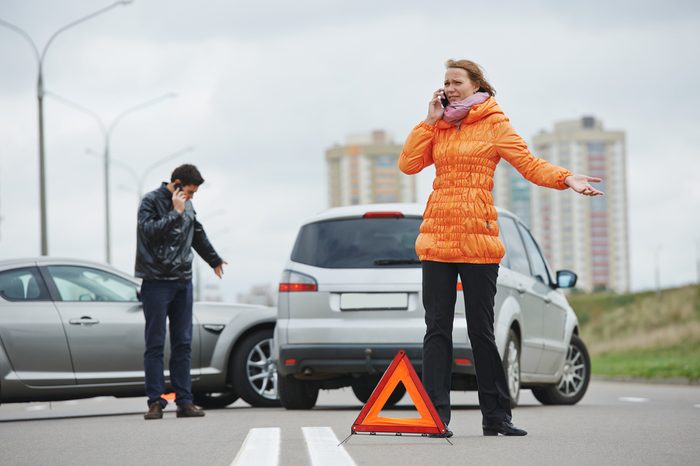 Car collision. driver man and woman examining damaged automobile cars after crash accident in city