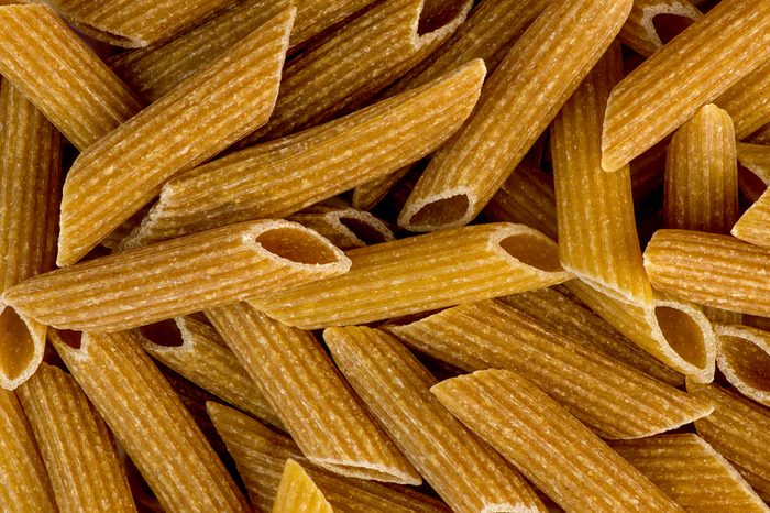 Macro closeup background texture of whole wheat rigatoni pasta