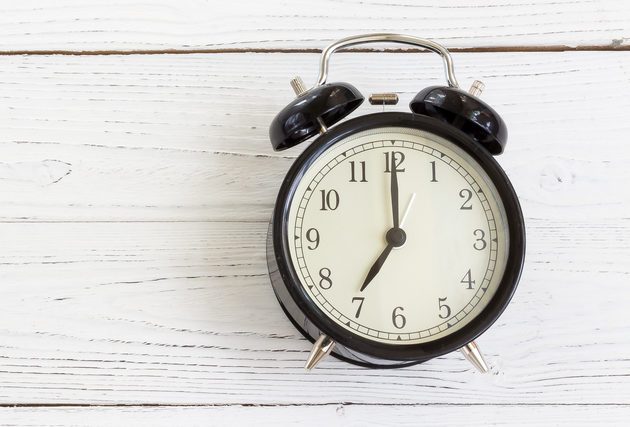 A black retro watch on a white wooden background