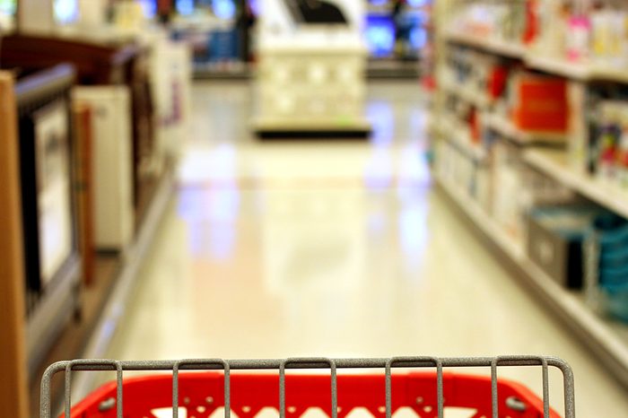 Red shopping cart in store aisle