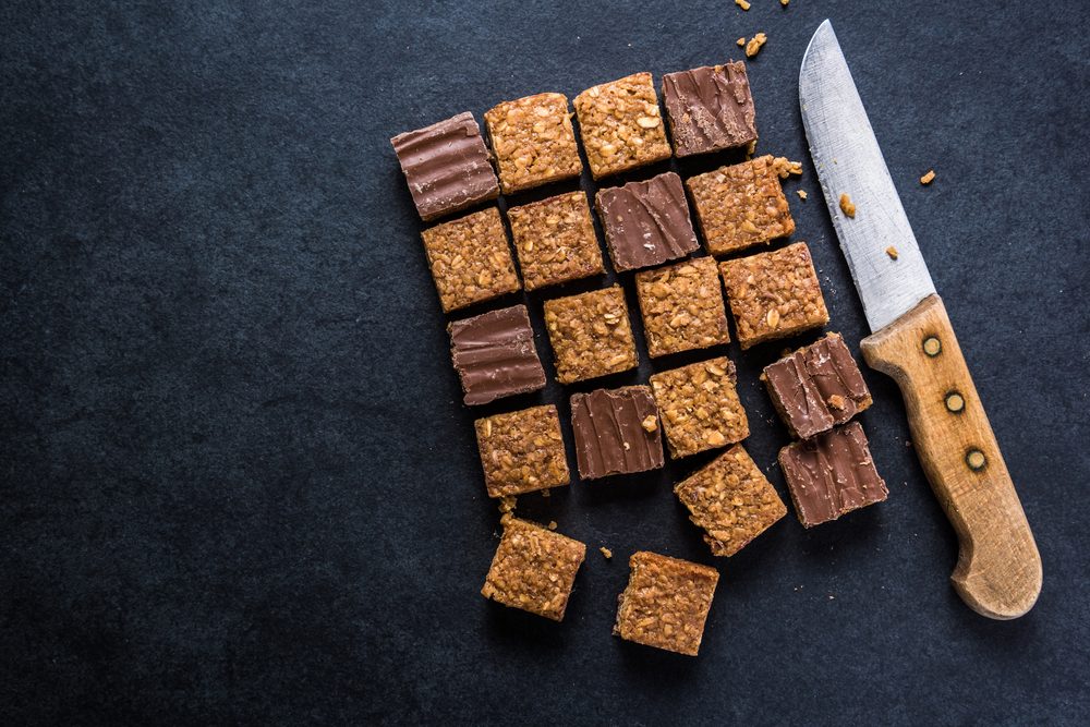Healthy diet snack, oat flap jack brownie bar. View from overhead on dark slate.