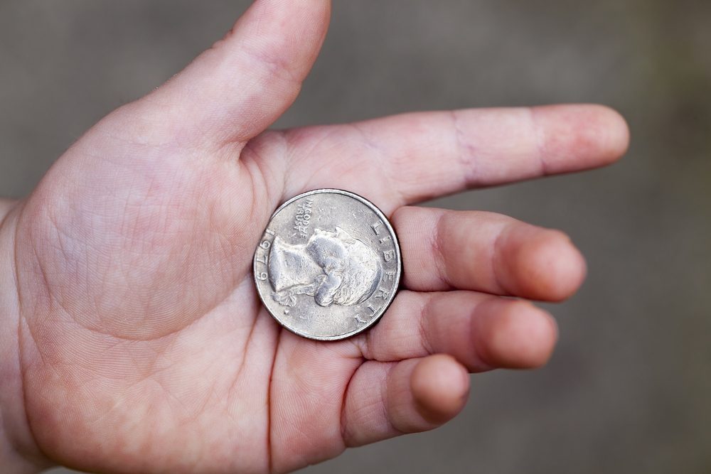  lying in the hand of the child's American coin in a quarter. Photo closeup with a small depth of field.