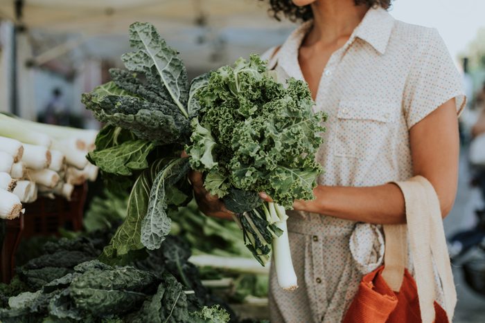 Beautiful woman buying kale at a farmers market