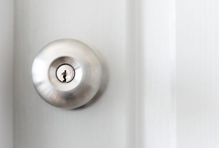white door with metal doorknob is regular lock style in a house, copy space.