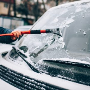 cleaning the glass machine from snow and ice brushing.