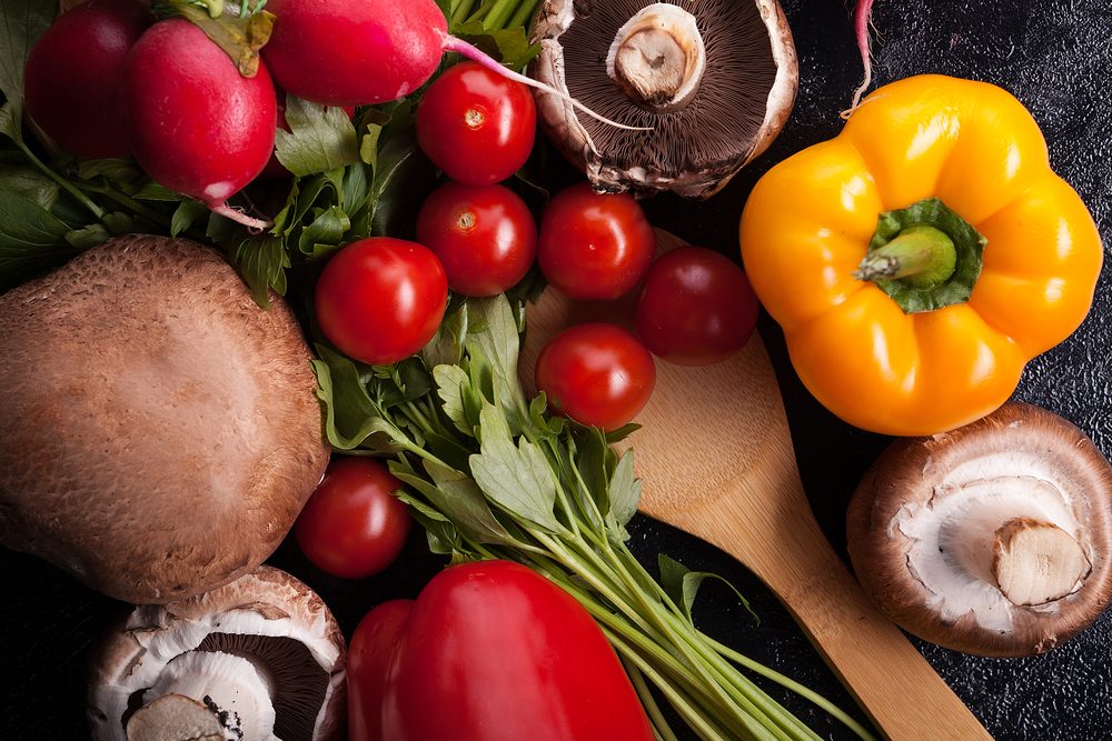 Close up image of different delicious fresh and healthy vegetables on dark background in studio photo