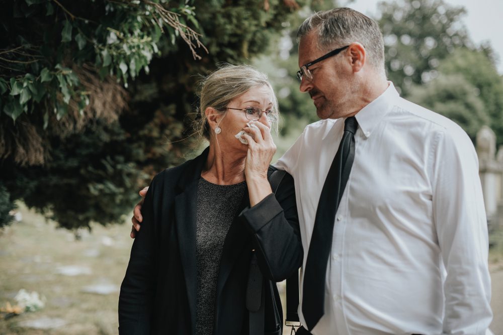 Husband trying to comfort his wife due to her loss