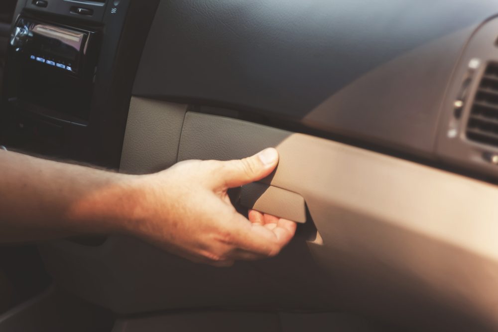 Male hand opens the glove compartment in the car, retro toningÑ?.