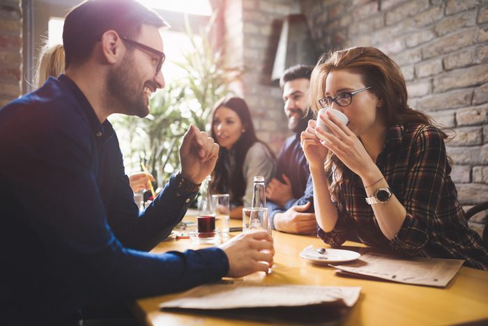 Happy colleagues from work socializing in restaurant and eating together