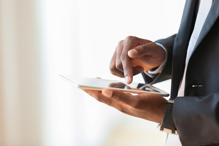 African american business man using a tactile tablet over white background - Black people