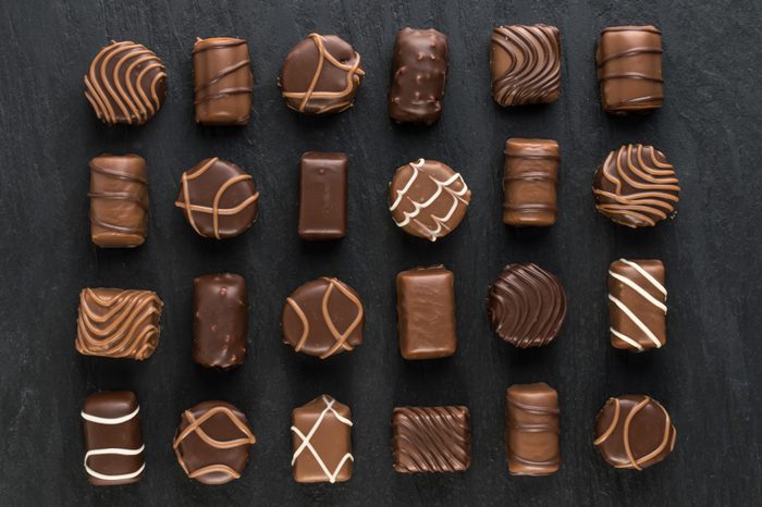 Beautiful Creative Chocolate Sweets on Natural Black Stone Background. Mix of Chocolates Top View and Flat Lay