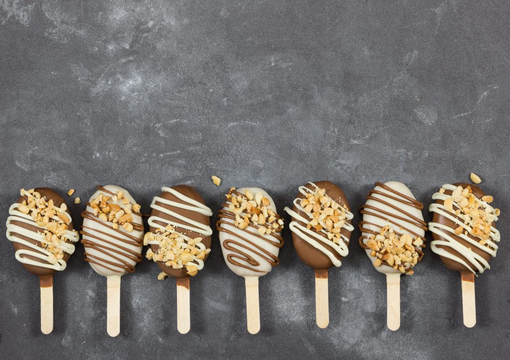 Cake pops in chocolate glaze in form of ice cream on gray stone background