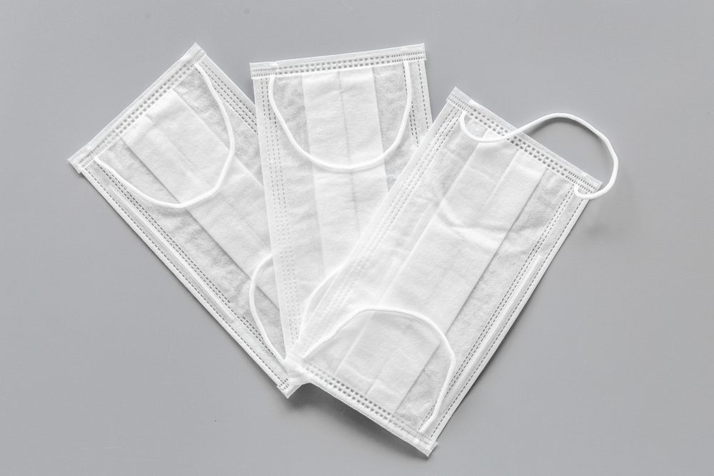 Flu prevention. Medical face masks on grey background top view