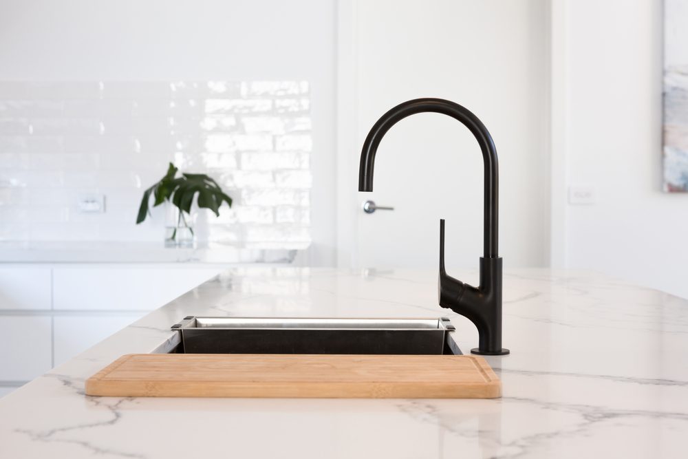 Monochrome kitchen detail of black gooseneck tap 