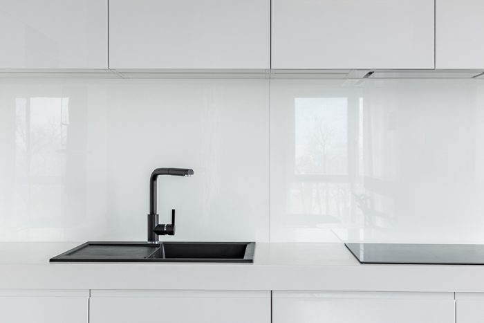 High gloss cabinets, countertop and black composite kitchen sink