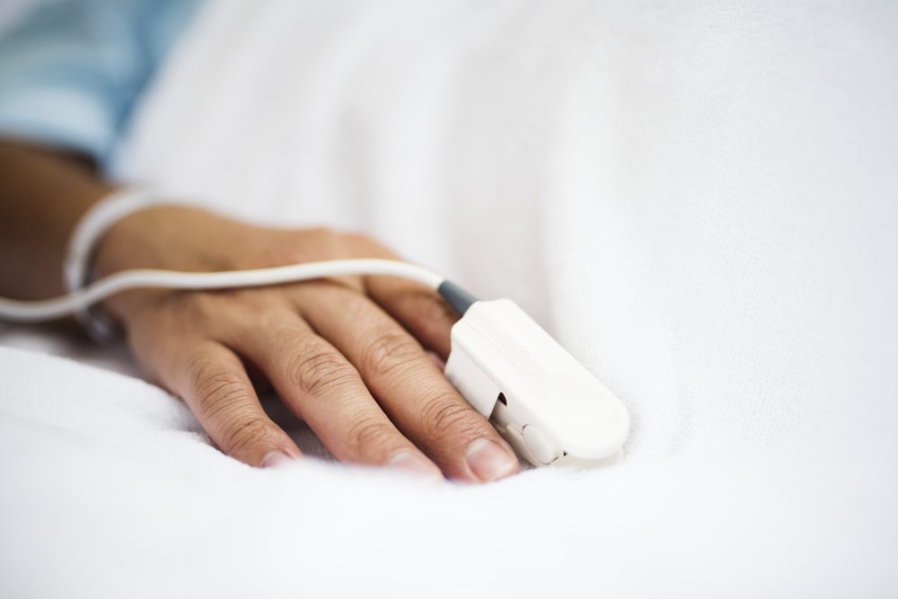 Closeup of hand with finger pulse oximeter