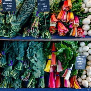 A closeup detail of a colorful display of organic vegetables at an outdoor farmers market in Seattle.