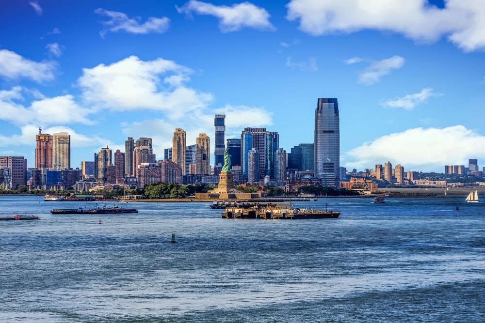 The skyline of Jersey City, New Jersey from New York Harbor with the Statue of Liberty in the foreground