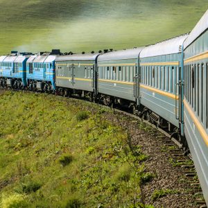 Transsiberian Railway with locomotive and steam crossing through Mongolia on a sunny summer day (near Ulaanbaatar, Mongolia, Asia)