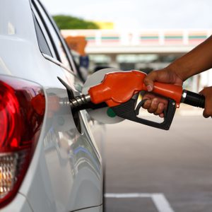 transportation and ownership concept - man pumping gasoline fuel in car at gas station