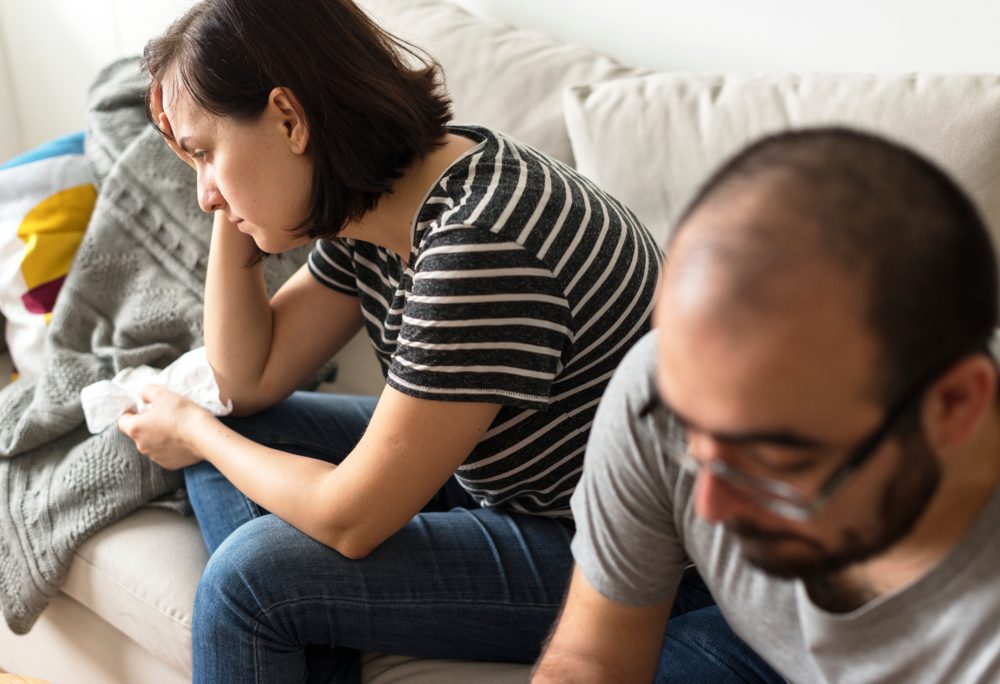 Unhappy couple arguing on the sofa