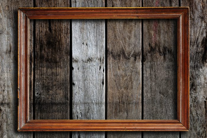 Old picture frame on vintage wood wall.