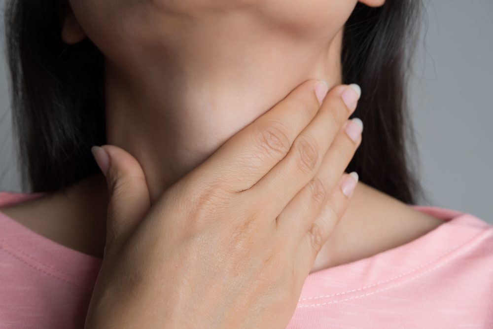 Sore Throat. Closeup Of Beautiful Young Woman Hand Touching Her Ill Neck. Healthcare and medical concept.