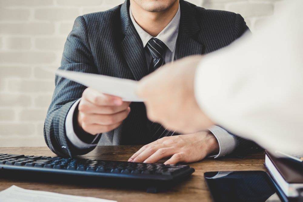 Businessman passing document to manager at the office