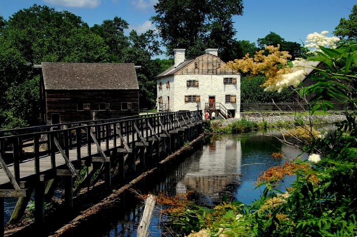 Sleepy Hollow, NY - July 9, 2009: The beautiful setting at historic c. 1750 Philipsburg Manor with the grist mill at left and the Frederick Philipse Manor house