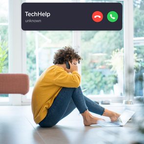 woman using a computer while on the phone with incoming call interface overlay