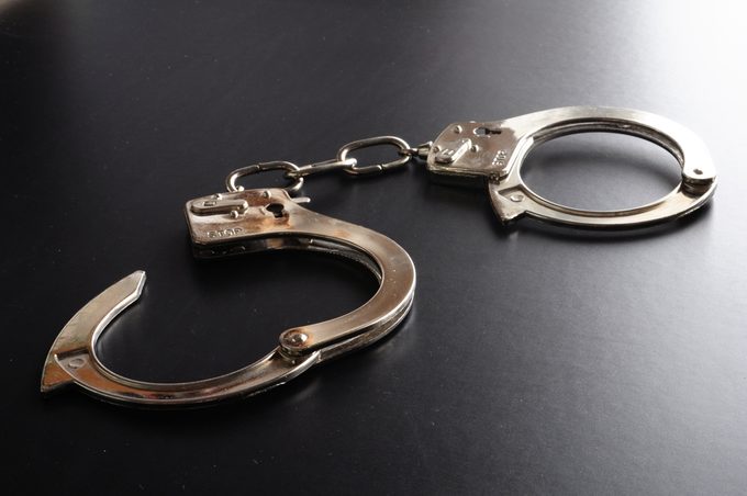 crime and law concept with police handcuffs on desk