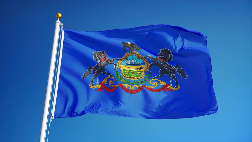 Pennsylvania (U.S. state) flag waving against clear blue sky, close up, isolated with clipping path mask alpha channel transparency, perfect for film, news, composition