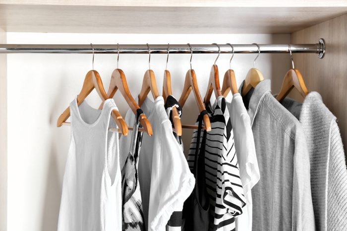 Hangers with different clothes in wardrobe closet