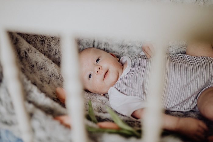 Cute newborn baby boy in a bed