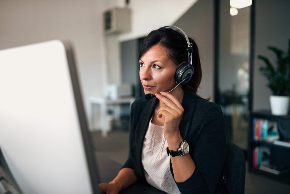 Close-up image of freelance operator talking with headsets and consulting.