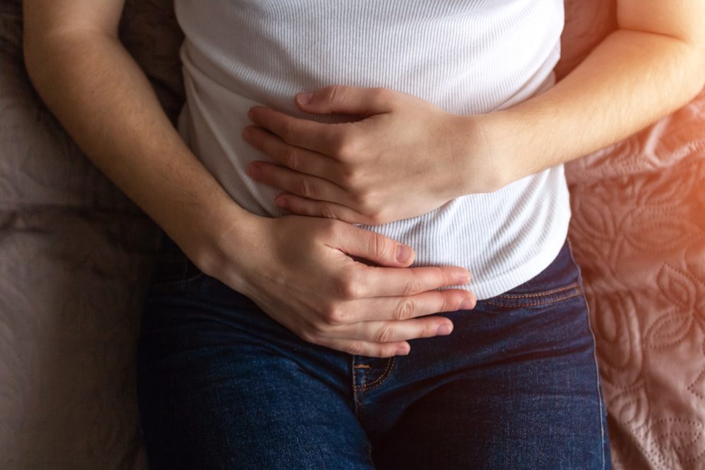 Young woman feels bad and experiences abdominal pain during the period of PMS and menstruation. Painful menstruation. Inflammation and Bladder Infection