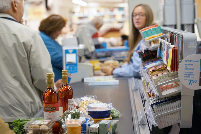 Customer buying food at supermarket and making check out with cashdesk worker in store. Shopping, sale, consumerism and people concept. 7 September 2018. Amsterdam. Netherlands