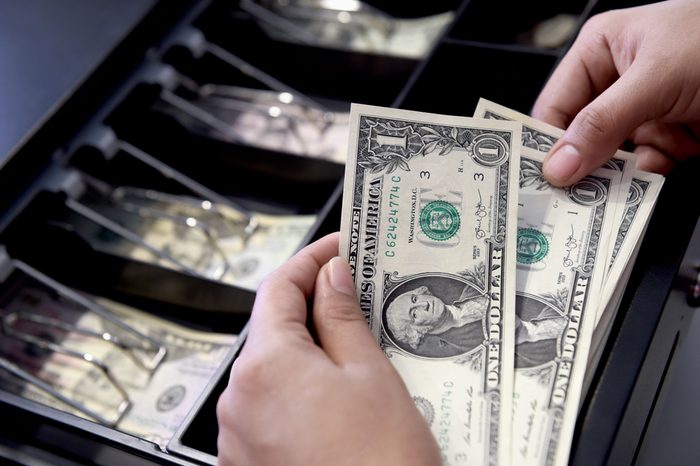 High angle view of cashier searching for change in cash