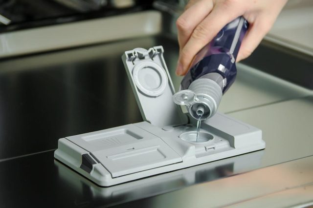 placing the dishwasher detergent for dirty dishes.