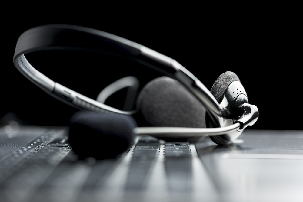 Headset lying on a laptop computer keyboard conceptual of online communication or a call centre, low angle view